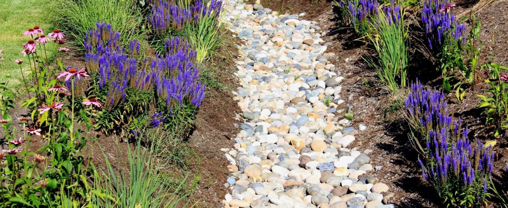 A planter bed with a line of river rock down the center