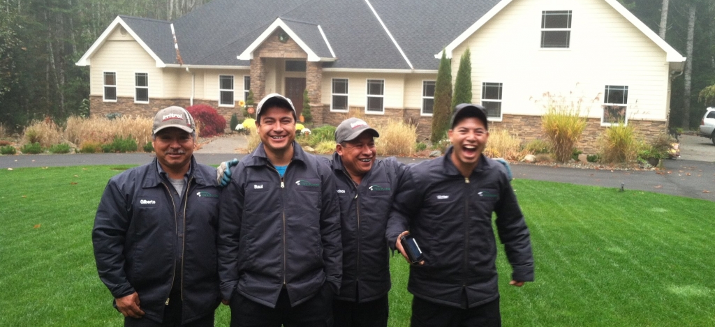 Four employees of Buds and Blades standing together and laughing.