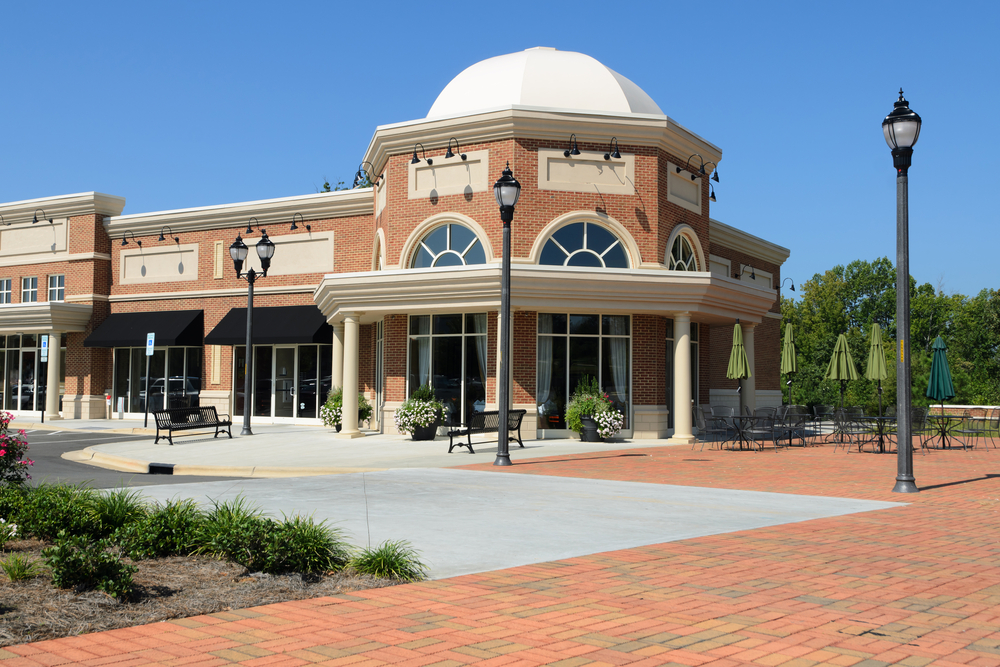 An all-brick commercial strip mall with a large patio surrounded by brick.